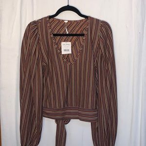 Faux wrap blouse with a cutout on the back of shirt. Gathers sleeves at wrist.